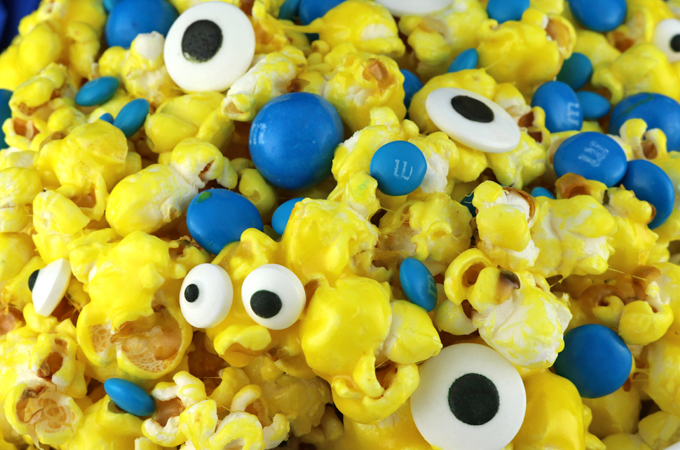 Minions Popcorn - sweet and salty popcorn mixed with M&M Candy and googly monster eyes will be a big hit with your family. It is both fun and delicious, a great combination! A fun anytime snack that would also be a great Party food at a Minions Birthday Party or a Despicable Me Family Movie Night. Pin this easy to make dessert for kids for later and follow us for more great Popcorn Recipe Ideas.