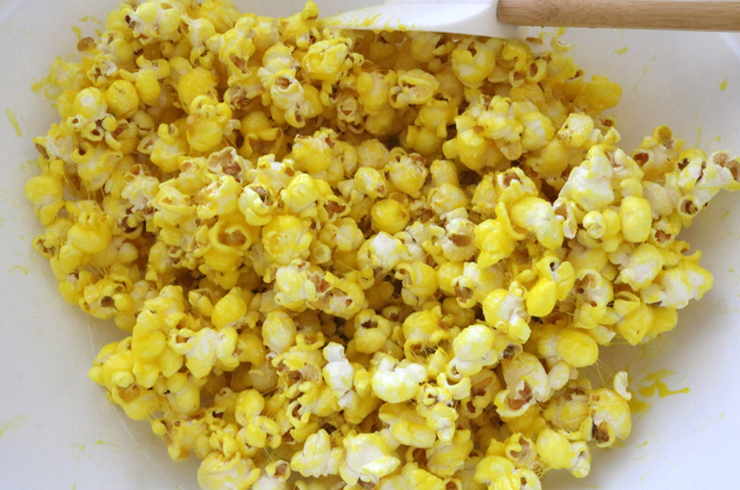 Stir the popcorn until it is completely covered with the yellow marshmallow mixture